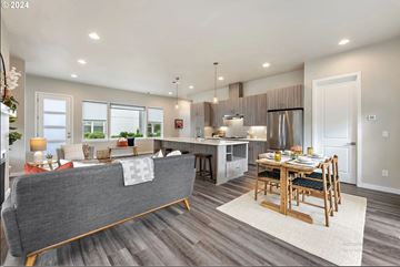 Portland townhouse for rent - A modern living room with a grey sofa and a wooden dining table set for two.