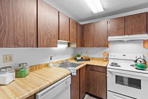 Kennewick apartment for rent - a kitchen with white appliances and wooden counter tops
