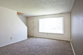 Kennewick apartment for rent - an empty living room with a large window and carpet