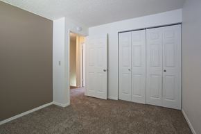 Kennewick apartment for rent - a bedroom with two closets and a door to a hallway