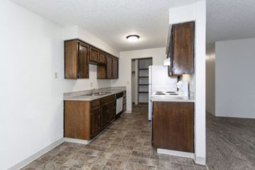 Kennewick apartment for rent - a kitchen with wooden cabinets and a white refrigerator