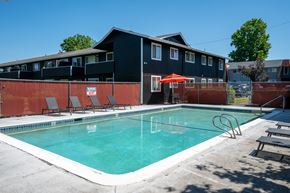 Beaverton apartment for rent - A swimming pool in front of a building with a red umbrella.