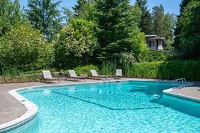 Portland apartment for rent - A swimming pool surrounded by trees and chairs.