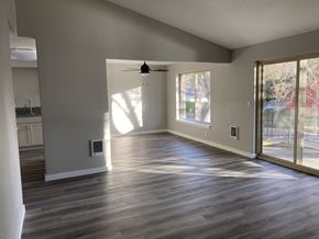 Eugene apartment for rent - A spacious room with a ceiling fan and sliding glass doors.