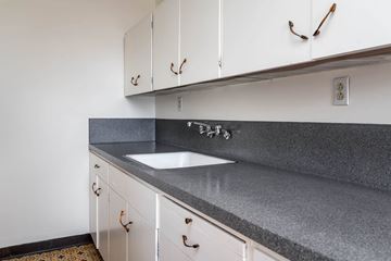 Portland apartment for rent - A kitchen with white cabinets and a grey countertop.