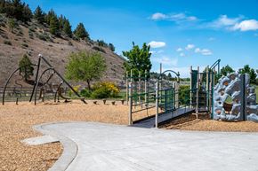 Bend apartment for rent - A playground with a slide, swings, and climbing wall.