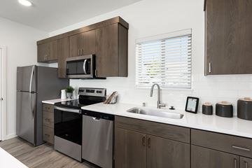 Vancouver townhouse for rent - A modern kitchen with dark wood cabinets and stainless steel appliances.