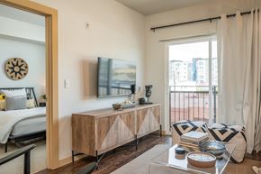 Everett apartment for rent - One Bedroom Apartments in Everett WA - The Waterline - Bedroom with Vinyl Hardwood Flooring, Area Rug, Stylish Decor, and Sliding Doors to the Balcony