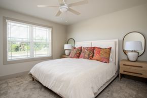 Boardman townhouse for rent - A bedroom with a white bed and a ceiling fan.