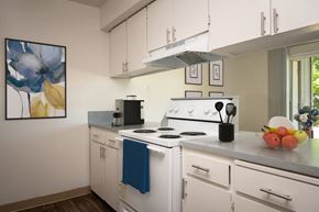Tigard apartment for rent - a kitchen with white appliances and white cabinets and a window