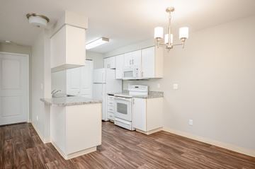 Clackamas apartment for rent - A kitchen with white cabinets and a wooden floor.