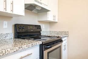 Tigard apartment for rent - A black stove top oven sitting on a granite counter.