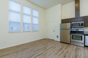 Vancouver apartment for rent - Kitchen open to living room with three large windows in living room.