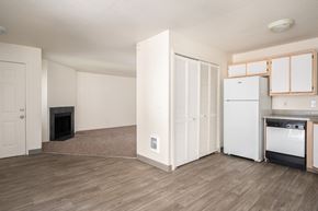 Tigard apartment for rent - a living room with a fireplace and a kitchen with a stove and refrigerator