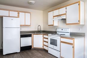 Tigard apartment for rent - a kitchen with white appliances and wooden cabinets