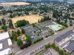 Vancouver apartment for rent - A parking lot is surrounded by trees and buildings.