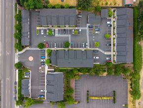 Vancouver apartment for rent - A parking lot with cars and a building in the background.