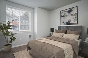 Vancouver apartment for rent - A bedroom with a large bed and a potted plant.