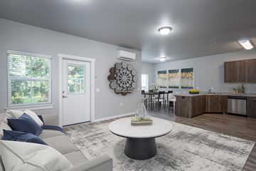 Vancouver apartment for rent - A modern living room with a white couch and a round table in the center.