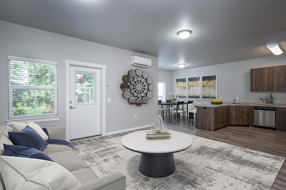 Vancouver apartment for rent - A modern living room with a white couch and a round table in the center.