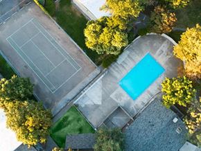 Kennewick apartment for rent - arial view of a tennis court and a pool in a backyard with trees