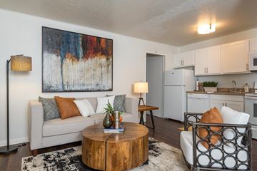 Portland apartment for rent - A living room with a couch, a coffee table, and a painting on the wall.
