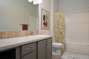 Vancouver apartment for rent - A bathroom with a toilet, sink, and shower curtain.