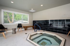 Corvallis apartment for rent - a spa with a hot tub in a room with chairs and a window