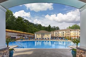 Raleigh apartment for rent - A large swimming pool surrounded by a stone wall and a white pillar at Crabtree Lakeside Apartments, North Carolina