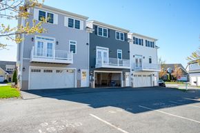 Charlottesville townhouse for rent - A two-story building with a garage and a balcony on the second floor.