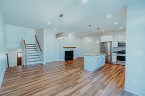 Charlottesville townhouse for rent - A spacious kitchen with wooden floors and white cabinets.