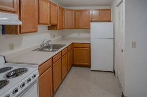 Colebrook apartment for rent - a kitchen with white appliances and wooden cabinets and a white refrigerator