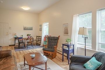 Littleton apartment for rent - an open living room and dining room with a table and chairs and a large window