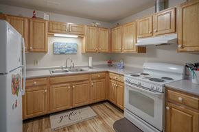 Littleton apartment for rent - a kitchen with white appliances and wooden cabinets