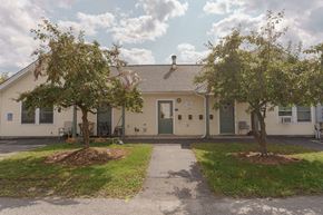 Littleton apartment for rent - a white house with two trees in front of it