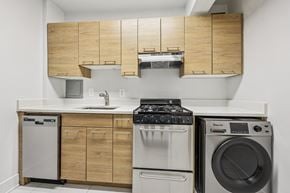 Washington apartment for rent - A modern kitchen with a stove top oven, dishwasher, and washing machine.
