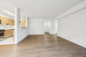 Washington apartment for rent - A spacious room with wooden flooring and white walls.