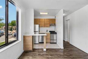 Washington apartment for rent - A modern kitchen with wooden cabinets and a white countertop.