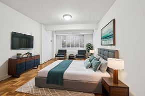 Washington apartment for rent - A bedroom with a bed, a chair, a cabinet, and a television.