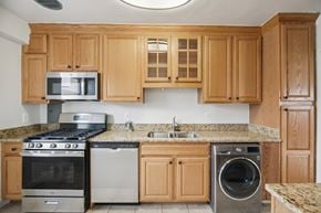 Washington apartment for rent - A kitchen with wooden cabinets and granite countertops.