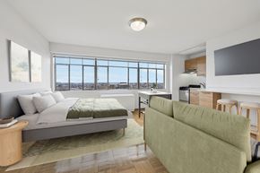 Washington apartment for rent - A bedroom with a large bed and a green couch.