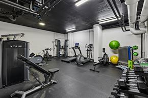Washington apartment for rent - A gym with a variety of equipment including a leg press machine, a treadmill, and a stationary bike.