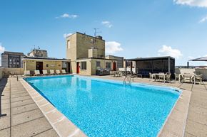 Washington apartment for rent - A large swimming pool in front of a building with a blue sky in the background.