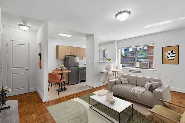 Washington apartment for rent - A modern living room with a grey couch, a coffee table, and a dining table with chairs.