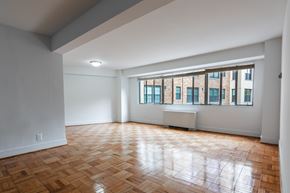 Washington apartment for rent - A room with wooden flooring and a window overlooking a building.