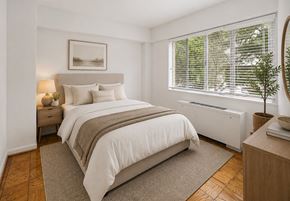Washington apartment for rent - A bedroom with a large bed and a window with blinds.