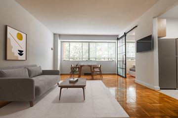 Washington apartment for rent - A living room with a grey couch, a coffee table, and a painting on the wall.