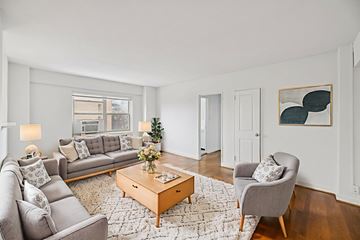 Washington apartment for rent - A living room with a grey couch, a coffee table, and a painting on the wall.