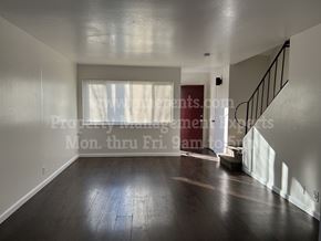 Stockton apartment for rent - A spacious room with wooden floors and a staircase.
