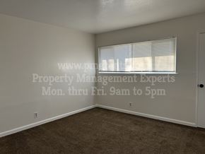 Stockton apartment for rent - A room with a window covered by blinds and a door on the right side.
